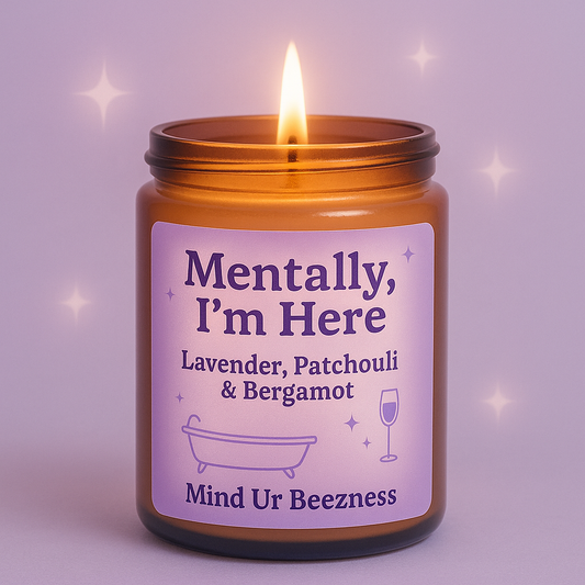 Close-up of the “Mentally, I’m Here” candle by Mind Ur Beezness, featuring a lavender, patchouli & bergamot blend, set against a dreamy purple soft girl background with sparkles.
